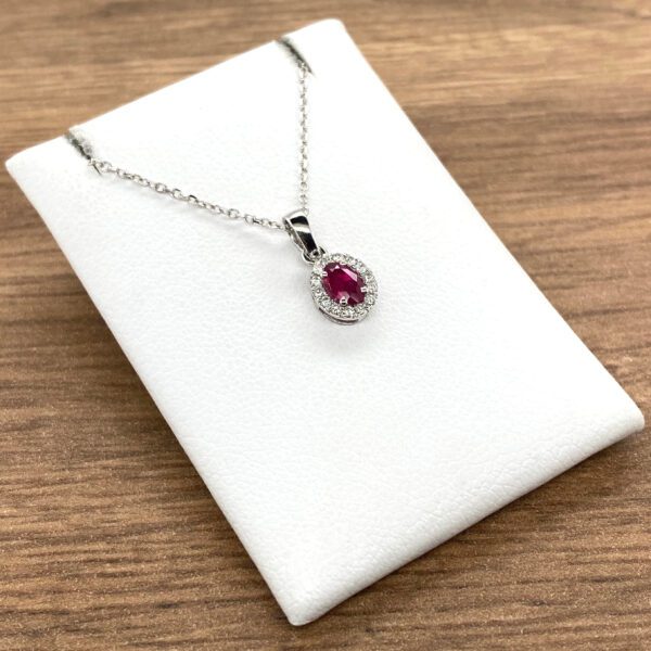 A Ruby & Diamond Oval Halo Cluster Pendant, 0.35ct with a ruby stone and diamonds.