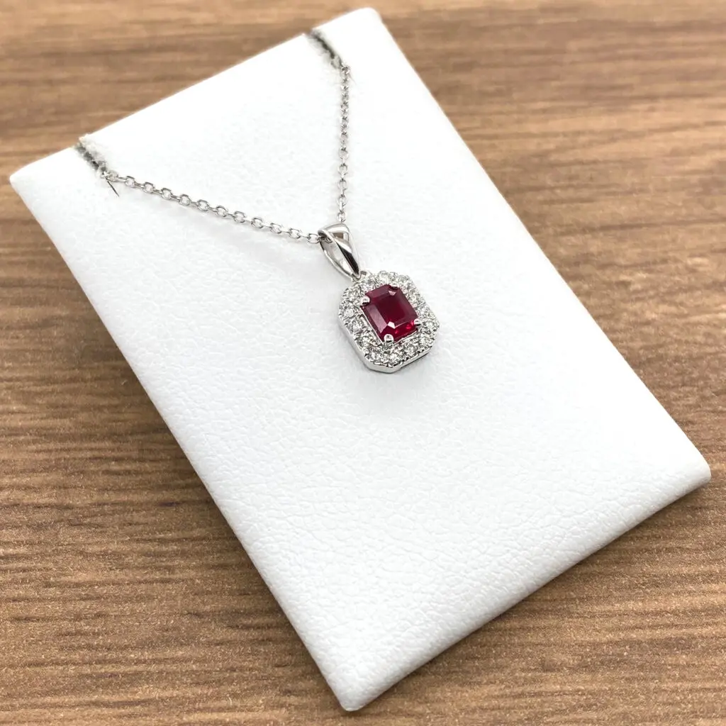 A Ruby & Diamond Rectangular Cluster Pendant with a ruby stone and diamonds.