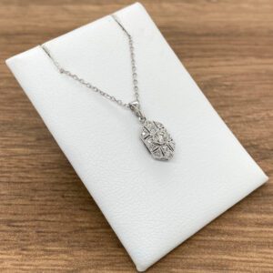 A white gold necklace with a diamond in the center.