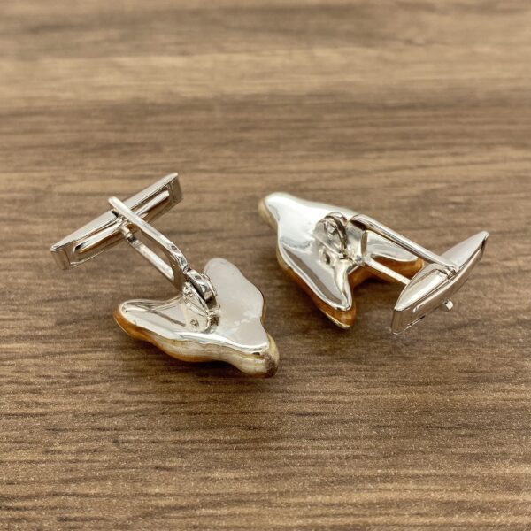 Silver cufflinks with a brown design.