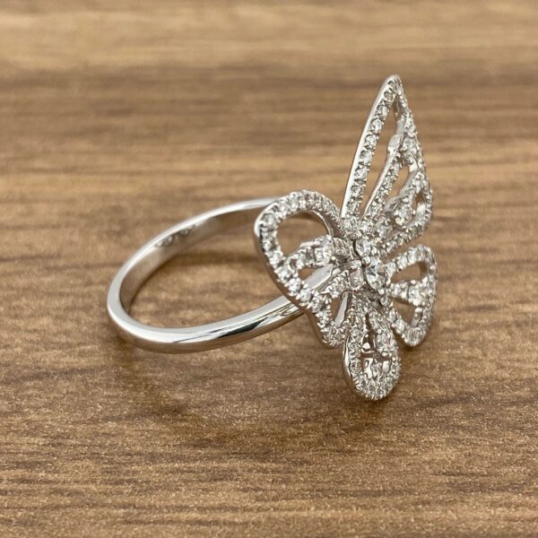 Diamond butterfly ring on wood background.