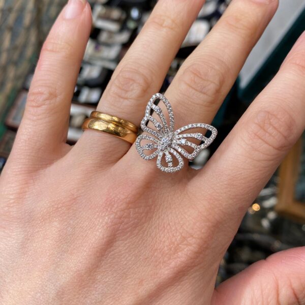 Diamond butterfly ring on a hand.