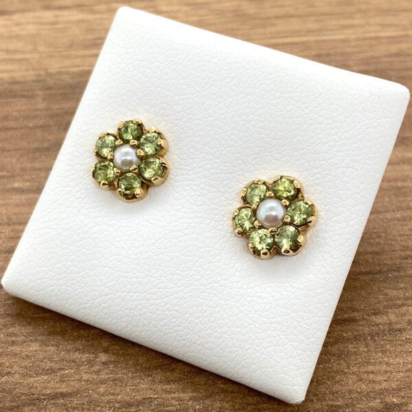 Gold flower earrings with green stones and pearls.