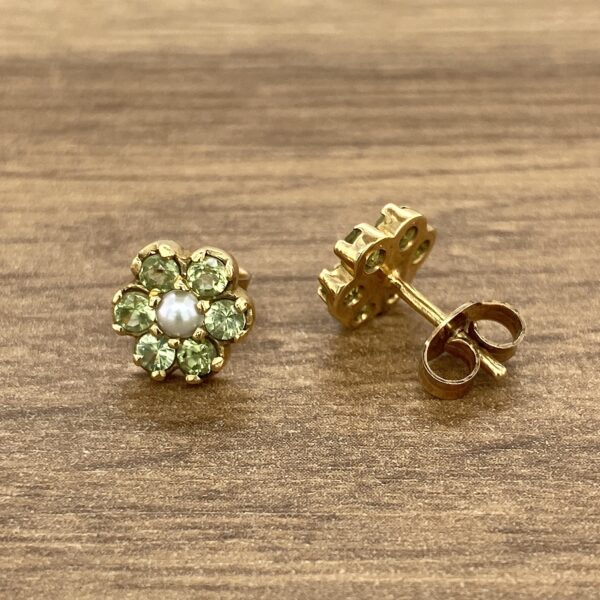 Gold flower earrings with green stones and pearls.