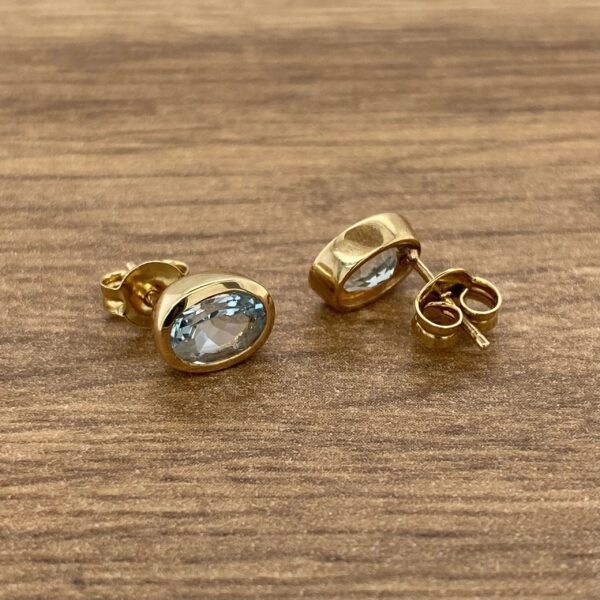 Gold earrings with oval blue stones.