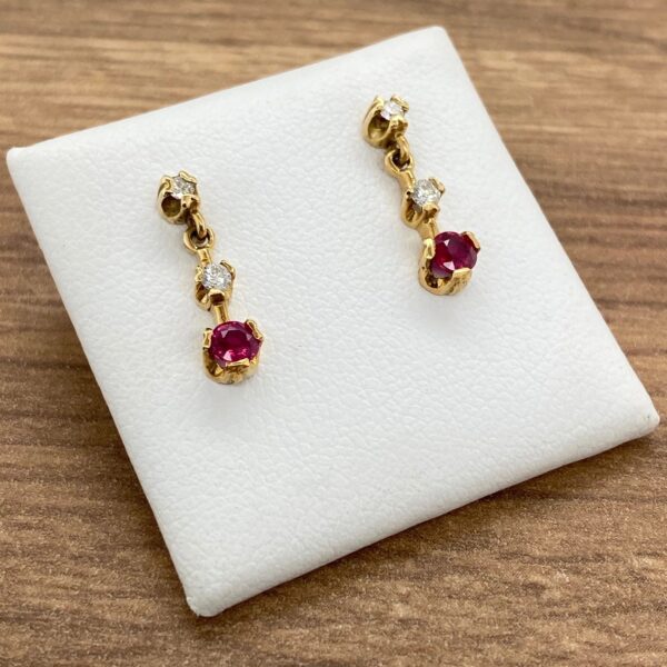 Gold earrings with ruby and diamond accents.