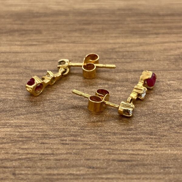 Gold earrings with ruby and diamond accents.