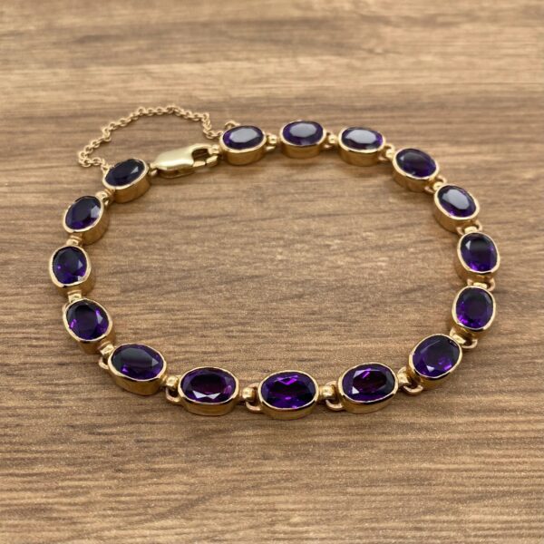 A gold plated bracelet with purple amethyst stones.