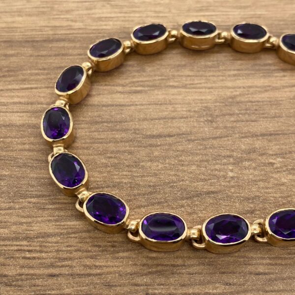 Gold bracelet with purple gemstones.