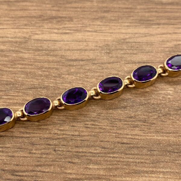 Gold bracelet with purple gemstones.