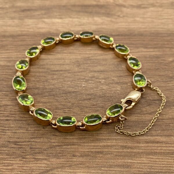 Gold bracelet with green gemstone links.