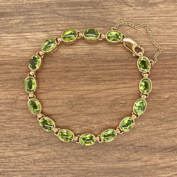 Gold bracelet with green gemstones.