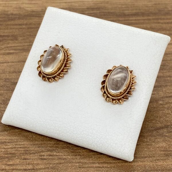 Gold earrings with oval clear stones.