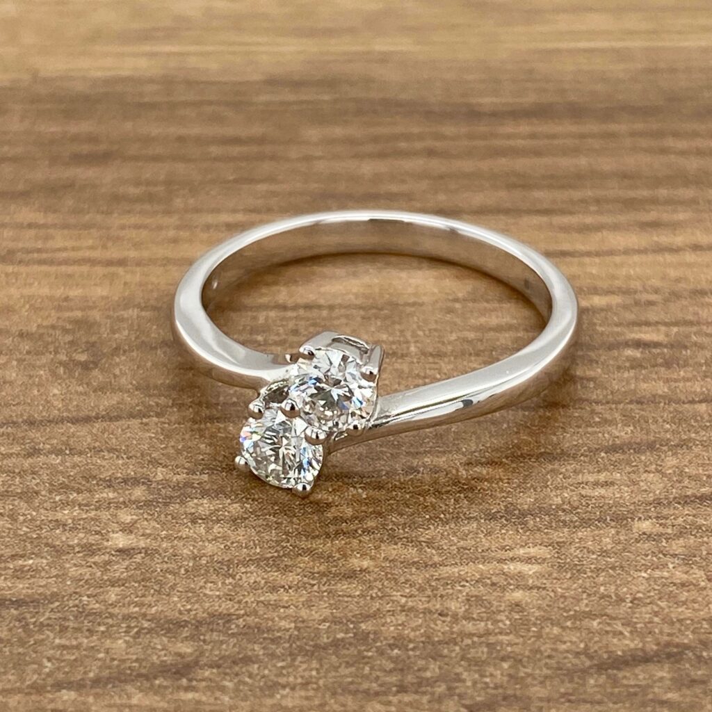 Diamond engagement ring on wooden background.