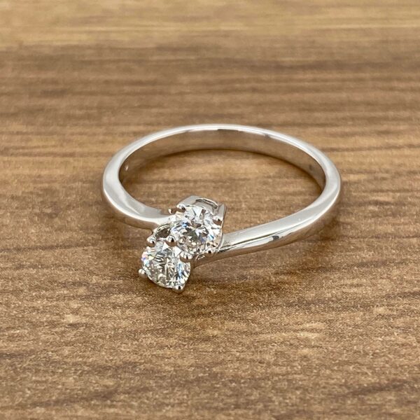 Diamond engagement ring on wooden background.