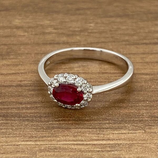 Oval ruby ring with diamond halo.