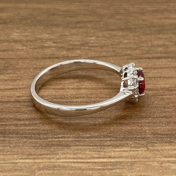 Silver ring with a red gemstone.