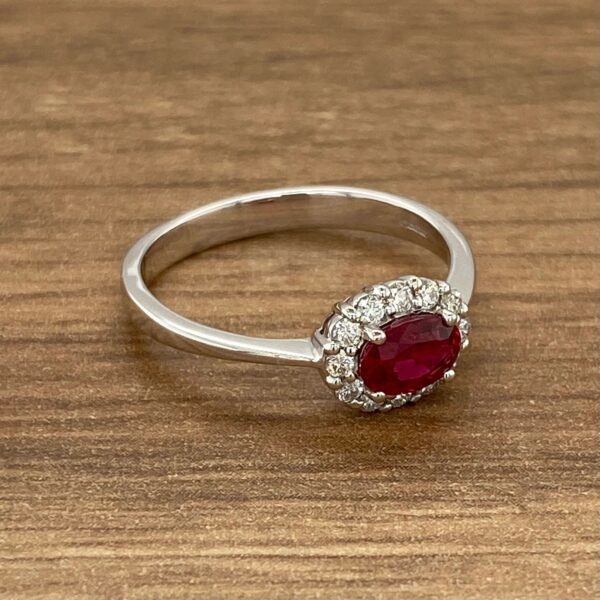 Oval ruby ring with diamond halo.