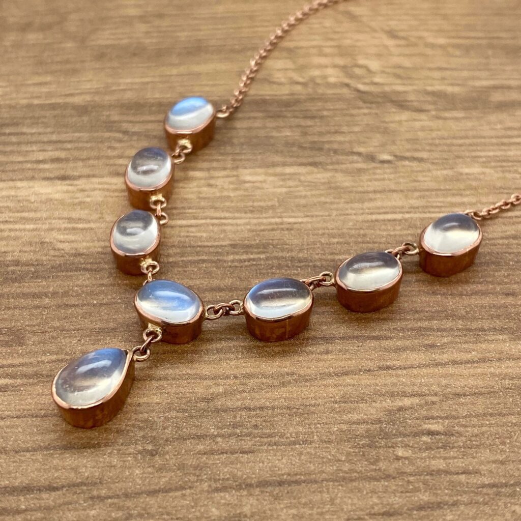 Moonstone necklace on a wooden table.