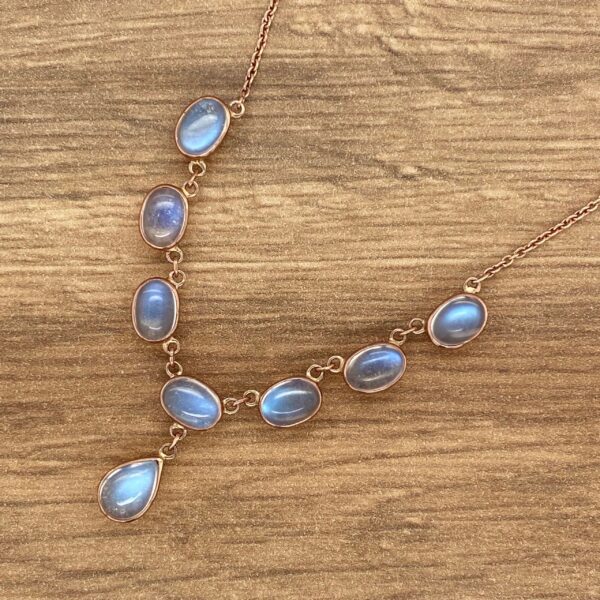 Gold necklace with blue gemstone pendants.