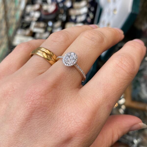 Hand with a diamond engagement ring.