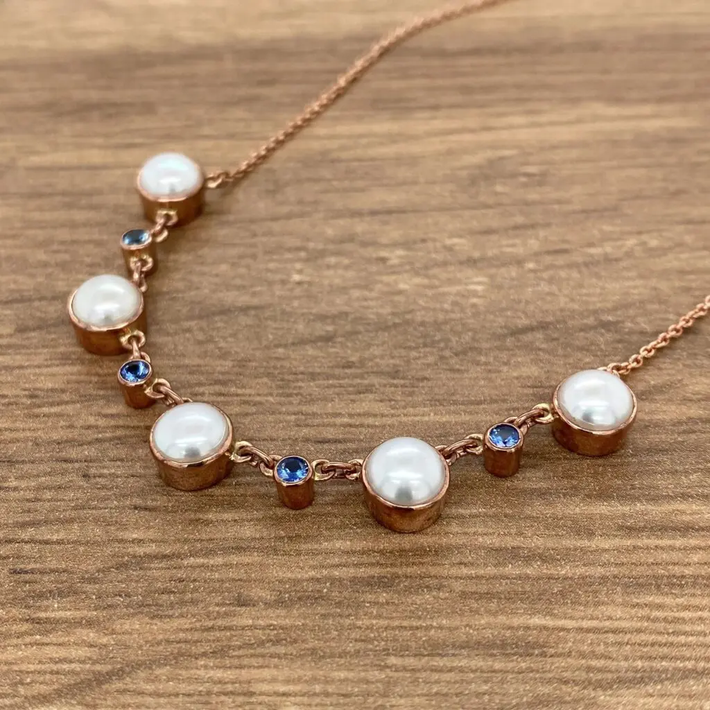 A necklace with pearls and blue sapphires.