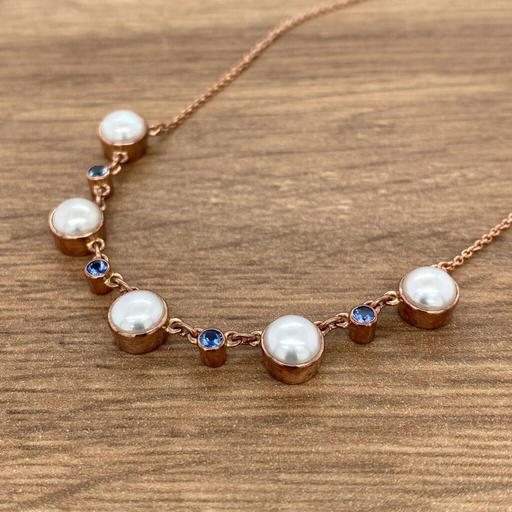 A necklace with pearls and blue sapphires.