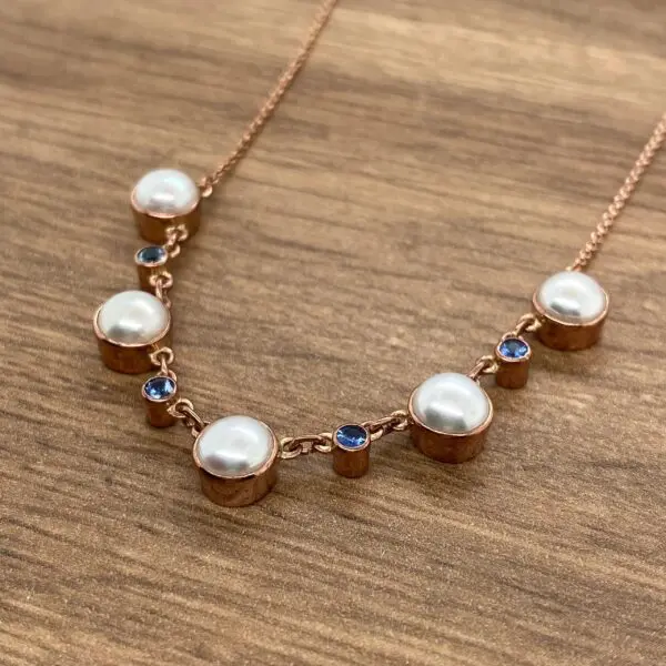 Rose gold necklace with pearls and sapphires.