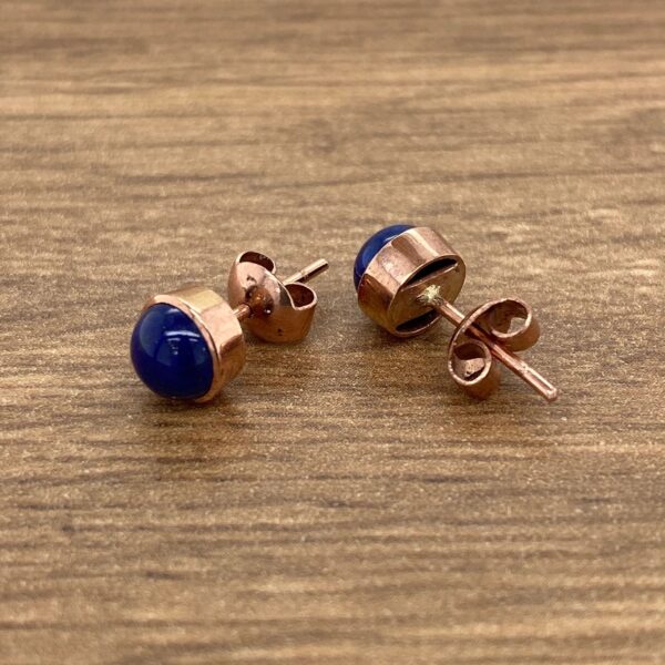 Rose gold stud earrings with blue stones.