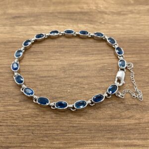 A sterling silver bracelet with blue sapphire stones.
