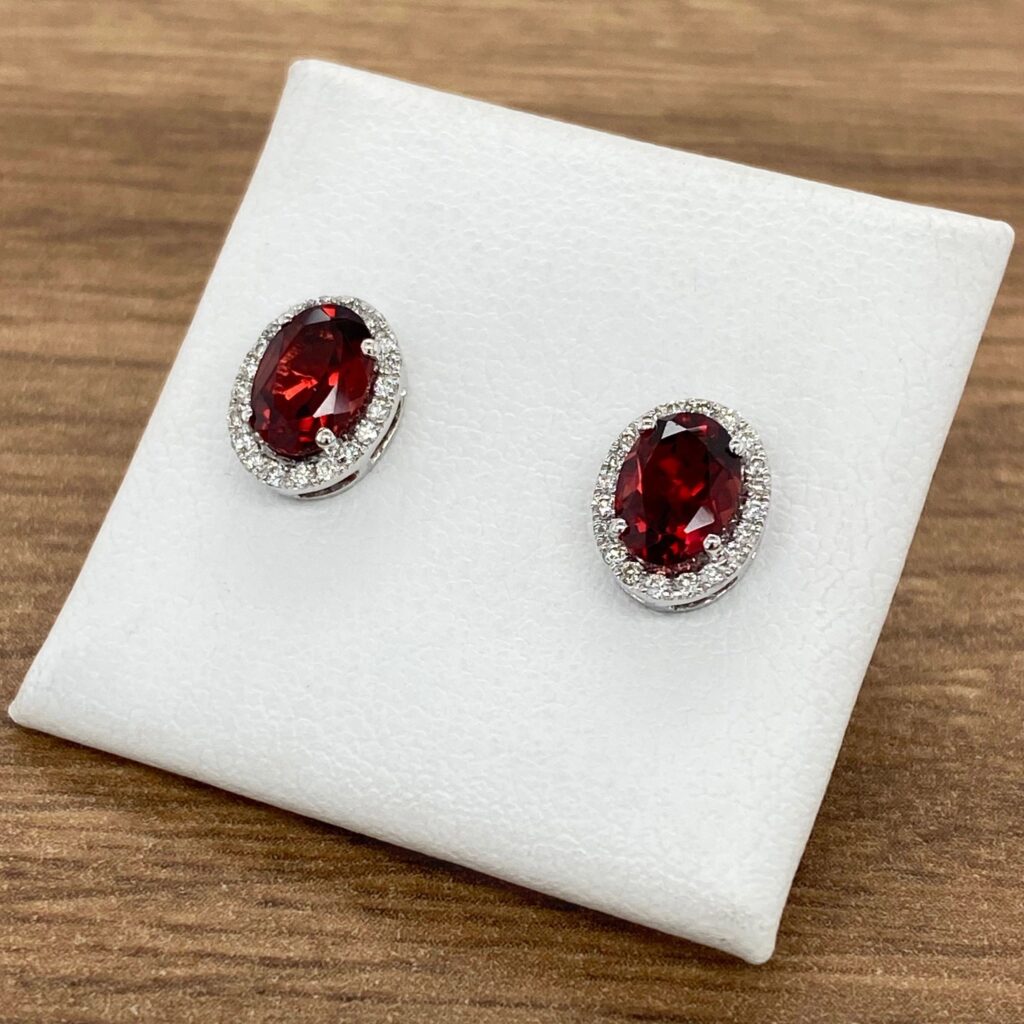 Red gemstone earrings with diamond halo.