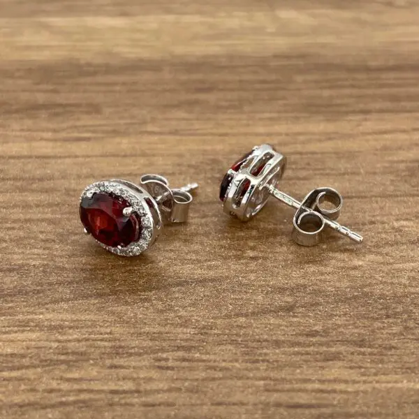 Silver earrings with red gemstones.