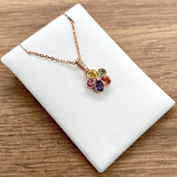 A Multicoloured Sapphire & Diamond Flower Cluster Pendant on a white background.