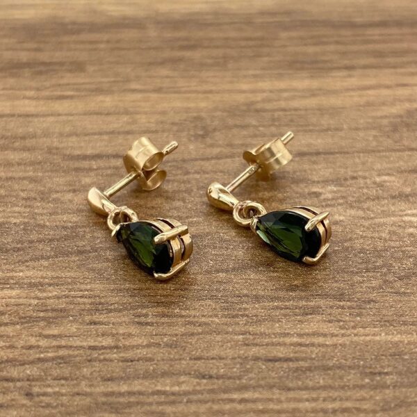 Gold teardrop earrings with green stones.