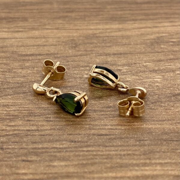 Gold earrings with green pear-shaped stones.