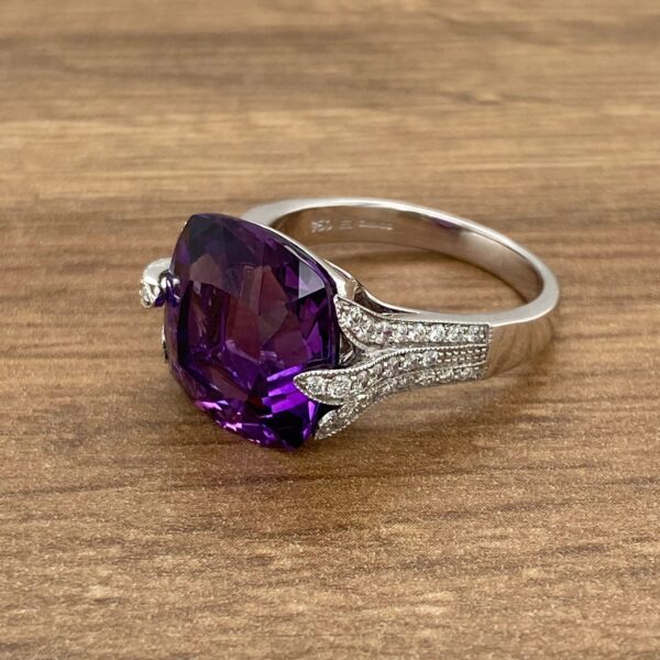 Amethyst and diamond ring on wood.