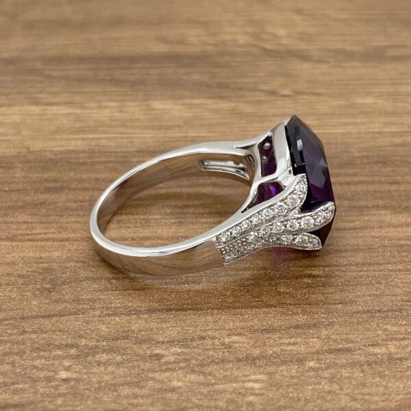 Amethyst and diamond ring on wooden surface.