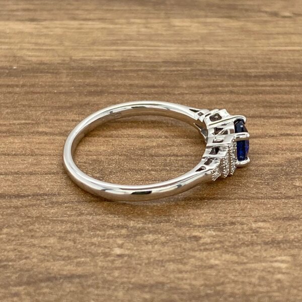 Side view of a sapphire and diamond ring.