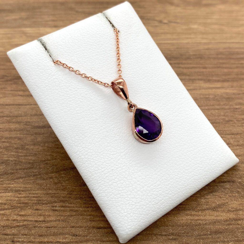 Rose gold necklace with amethyst pendant.