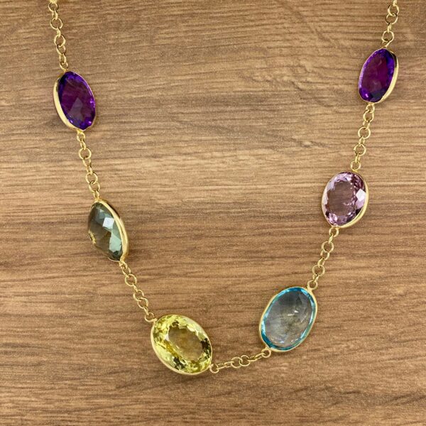 Gold chain necklace with colorful gemstones.