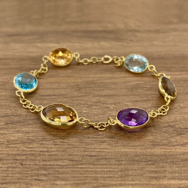 Gold bracelet with colorful gemstone accents.