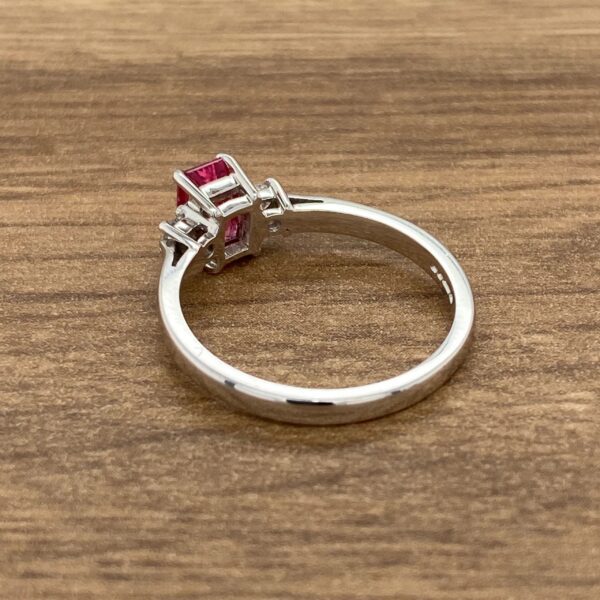 Silver ring with pink gemstone and diamonds.