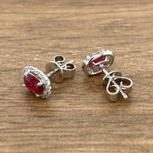 Silver earrings with ruby and diamond halo.