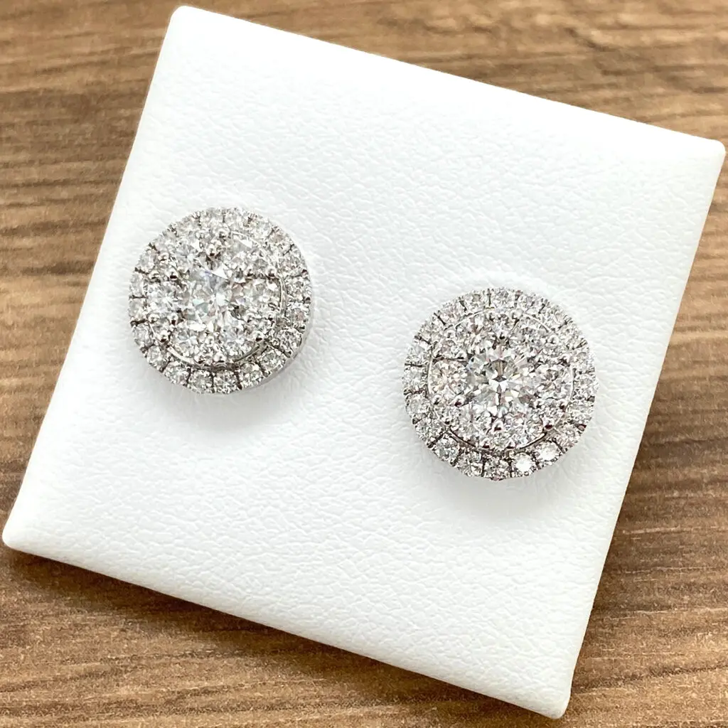 Diamond halo stud earrings on white background.