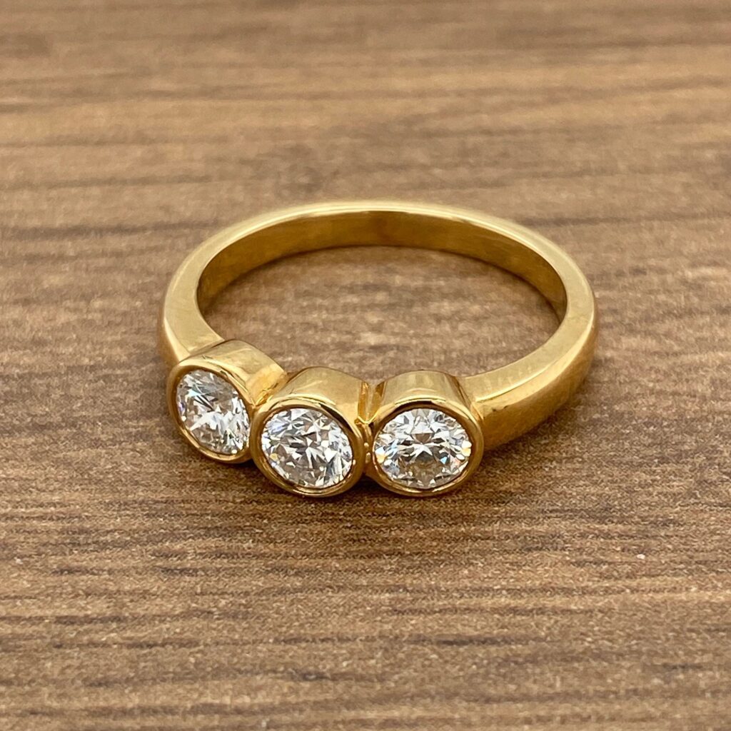 Gold ring with three round diamonds.