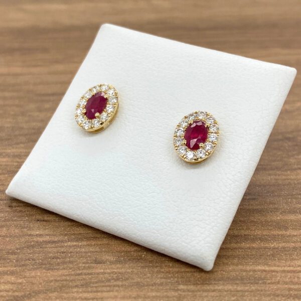 Gold earrings with ruby and diamond halo.