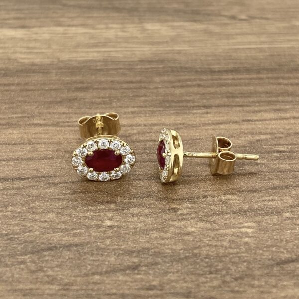 Gold earrings with ruby and diamond accents.