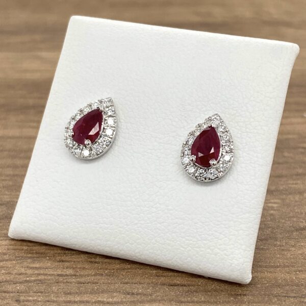 Pair of pear-shaped ruby earrings with halo setting.