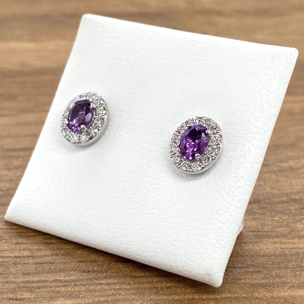 Pair of purple gemstone earrings with halo setting.