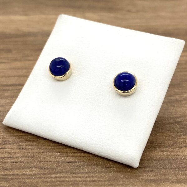 Gold stud earrings with blue gemstones.